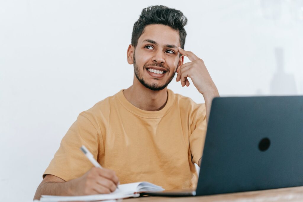 dreamy ethnic businessman thinking about project