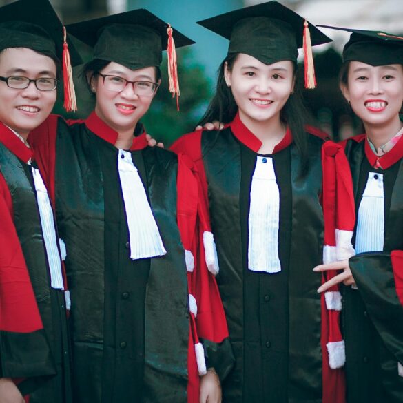 man and women wearing red and black academic gowns and black mortar boards