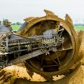 round brown and grey metal heavy equipment on sand