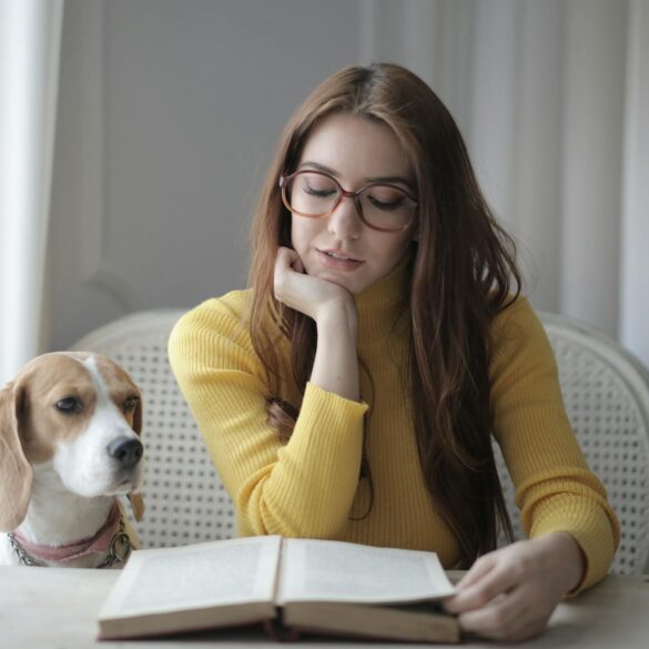 woman in yellow sweater while reading a book