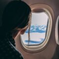 person holding smartphone riding airplane