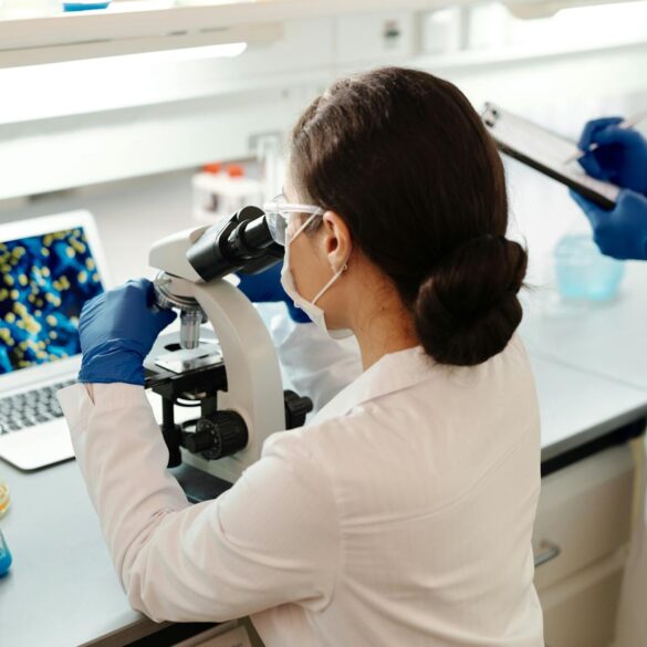 female laboratory scientist looking at a microscope