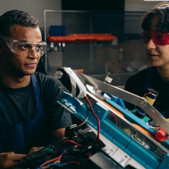 two boys wearing safety glasses near a metal frame